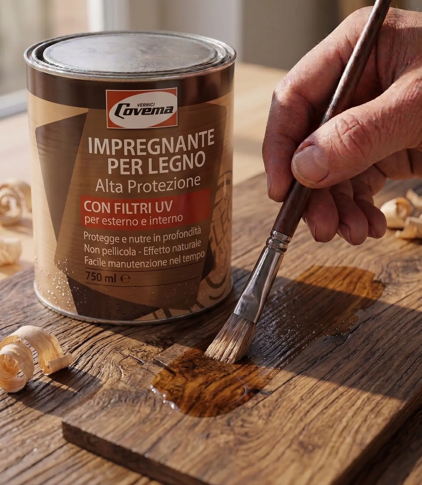 Die Dose Impregnante per Legno Alta Protezione mit UV-Filtern, daneben eine Hand, die das Produkt mit dem Pinsel auf ein Altholzbrett aufträgt