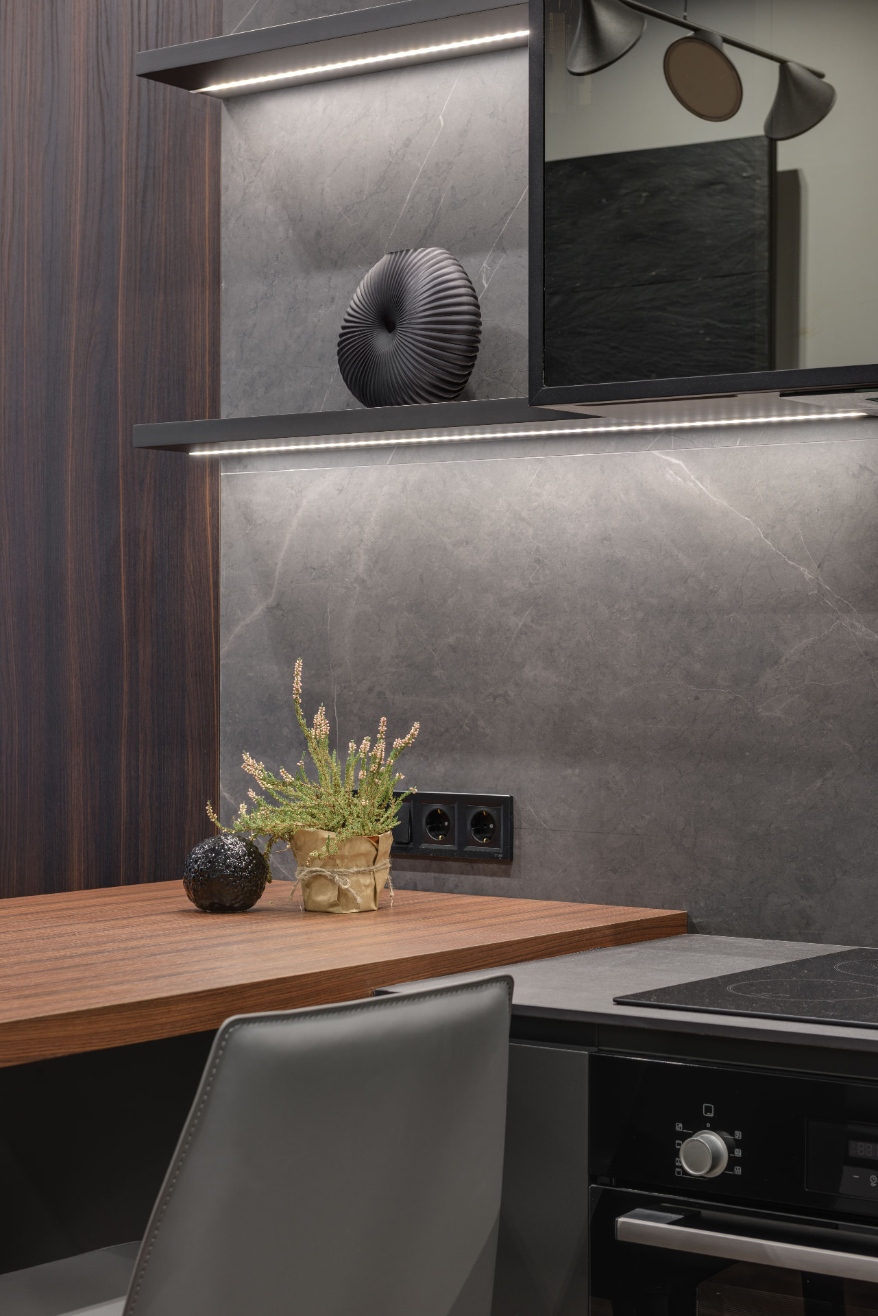 Cucina moderna con top in legno e parete in pietra grigia